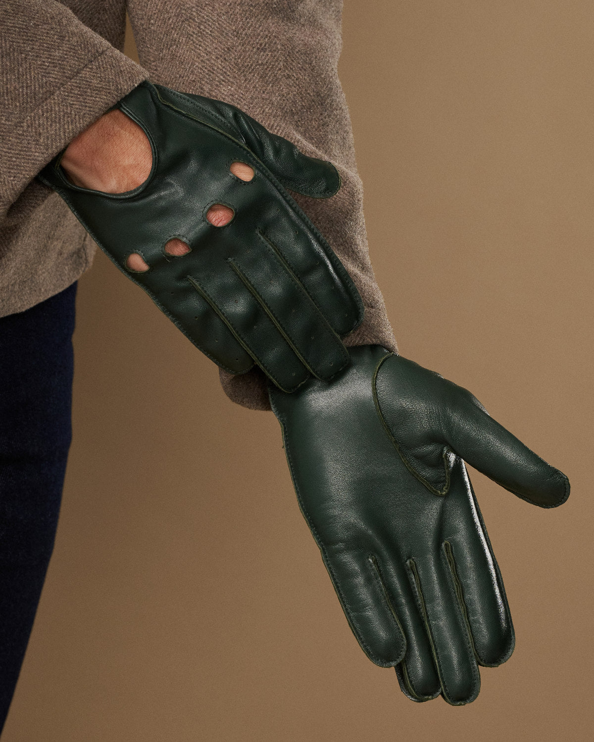 Dark green lambskin driving glove with stitched fingers and curved palm seam