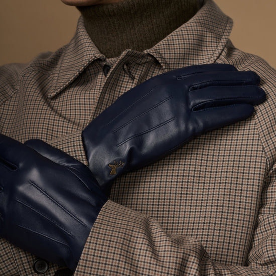 Navy leather glove close-up with stitched seams and small logo on the back