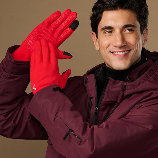 Red activity gloves with textured palms and black fingertips, worn by a model