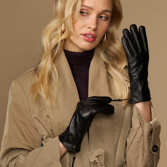 Black lambskin leather gloves with side zipper, worn by a model