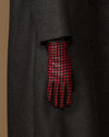 Single women's black leather glove showing red-and-black checkered back and fingers
