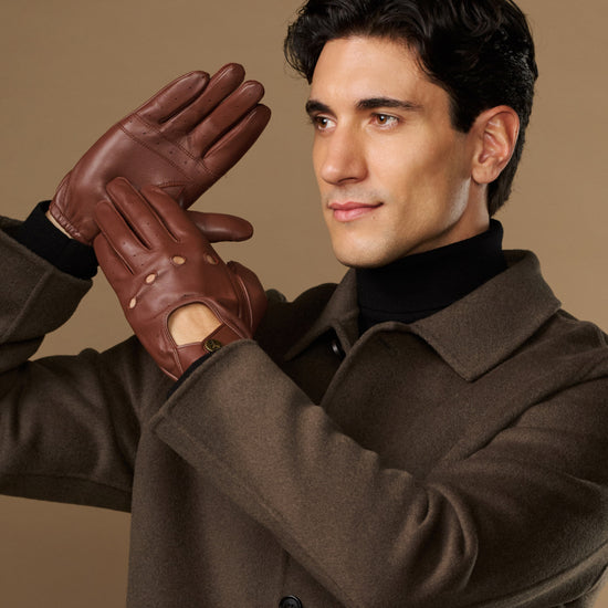 Men's brown leather driving gloves worn with elastic wrist and buttoned tabs