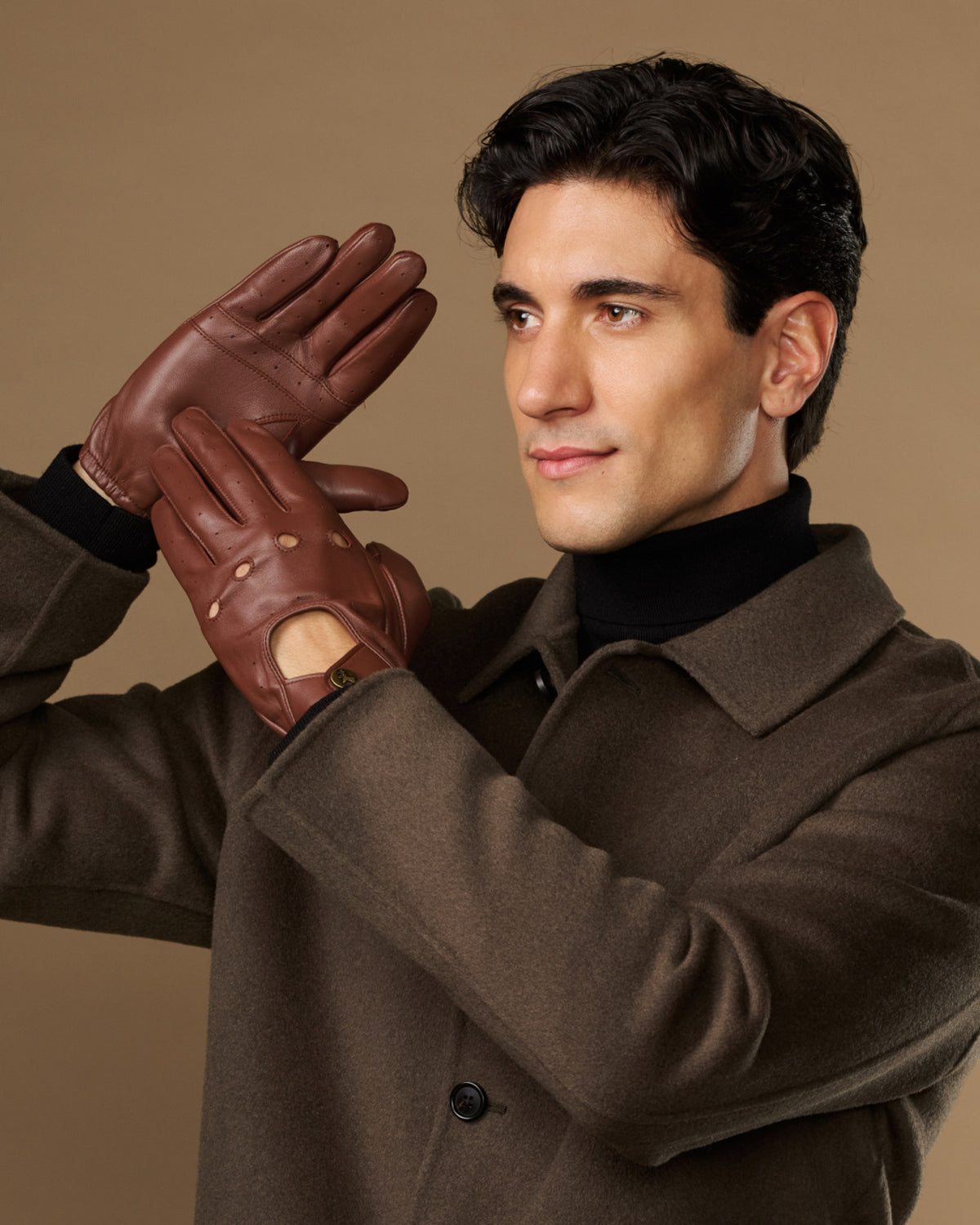 Men's brown leather driving gloves worn with elastic wrist and buttoned tabs