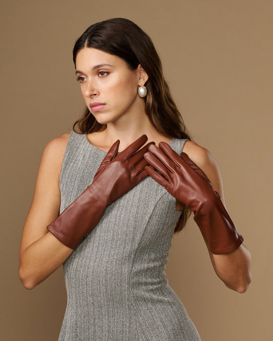 Chestnut brown mid-forearm leather gloves on model, smooth finish, five-finger design