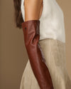 Close-up of chestnut brown leather opera glove sleeve and wrist cuff on arm