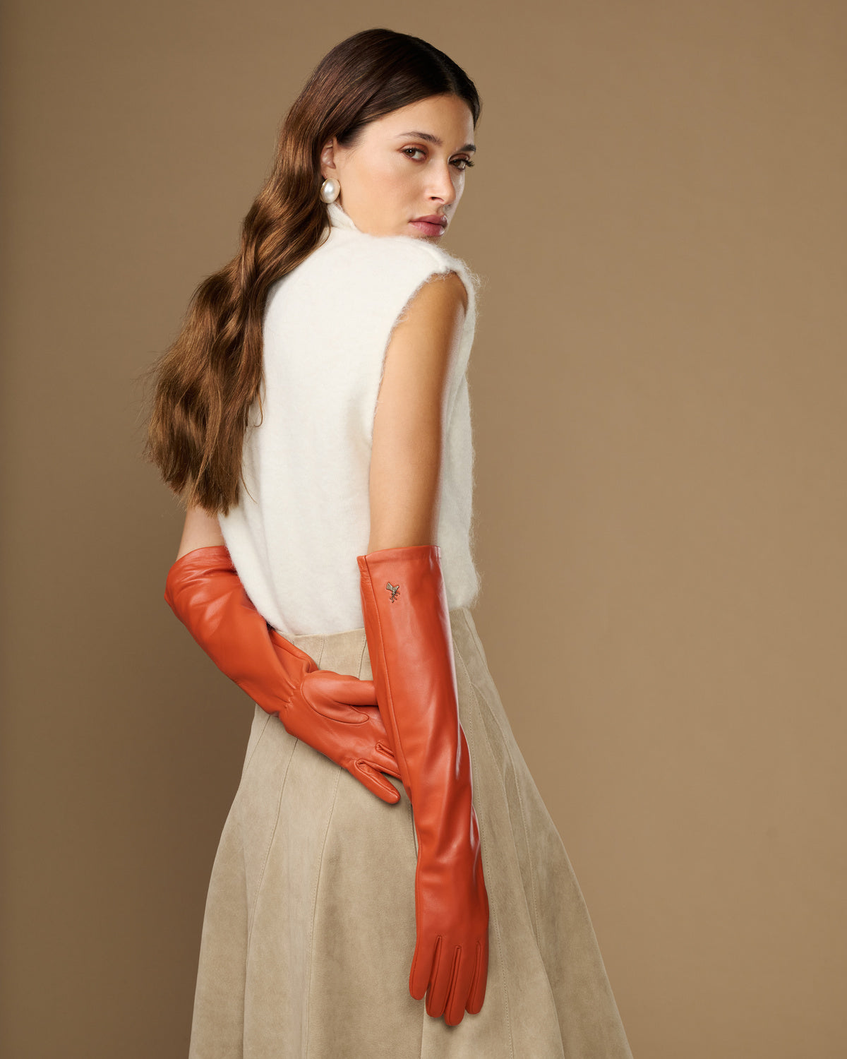 Orange leather elbow gloves shown from the side with long, fitted forearm coverage