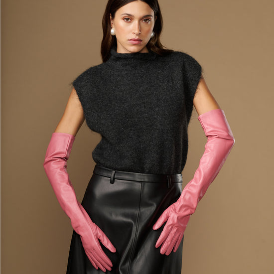 Women's pink leather gloves with long cuffs, hands resting forward