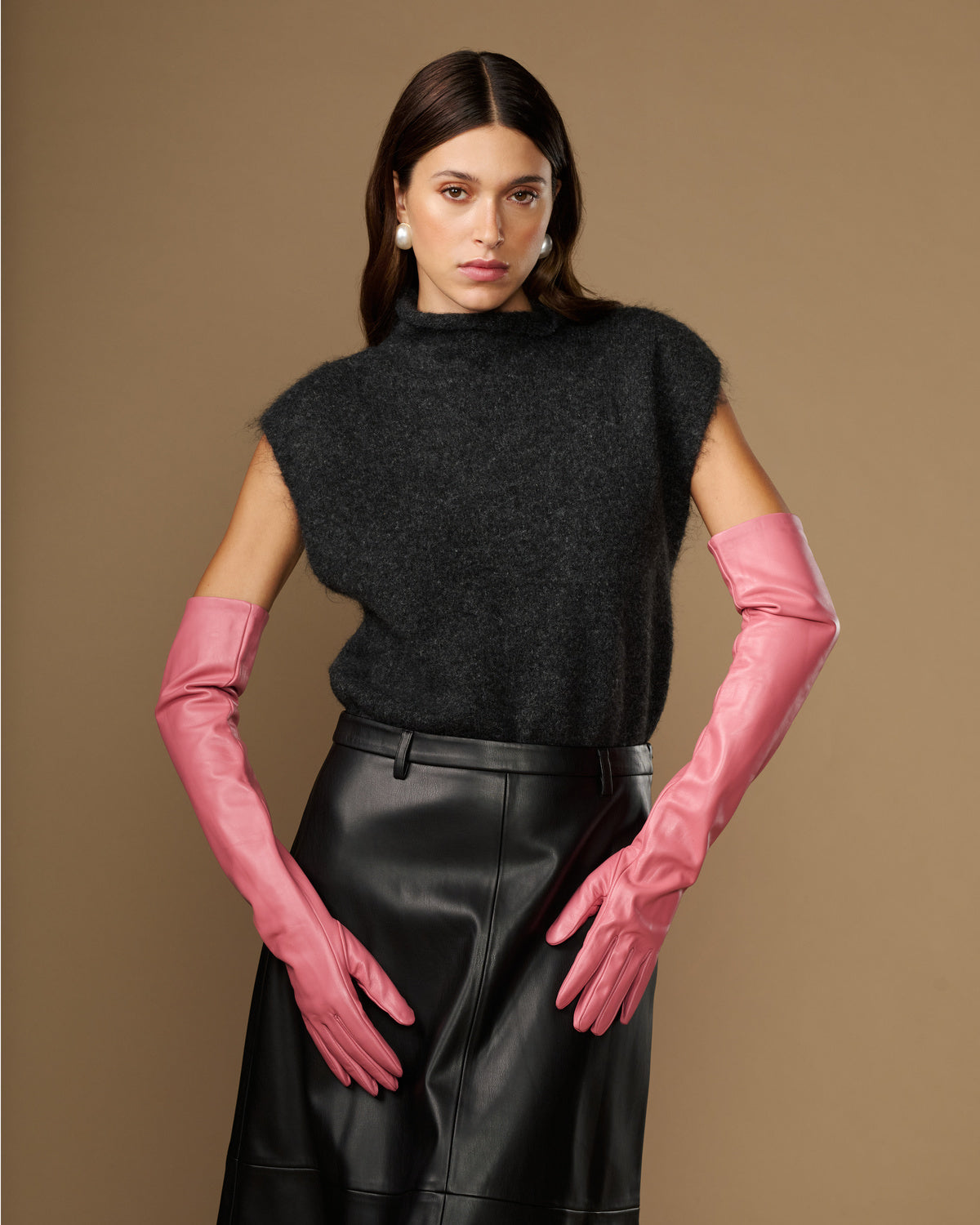 Women's pink leather gloves with long cuffs, hands resting forward