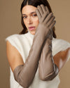 Close-up of taupe lambskin leather gloves with long cuffs and stitched fingers