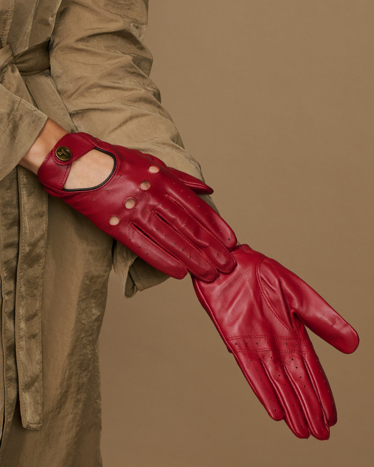 Red leather driving gloves on hand, full finger coverage with knuckle cutout